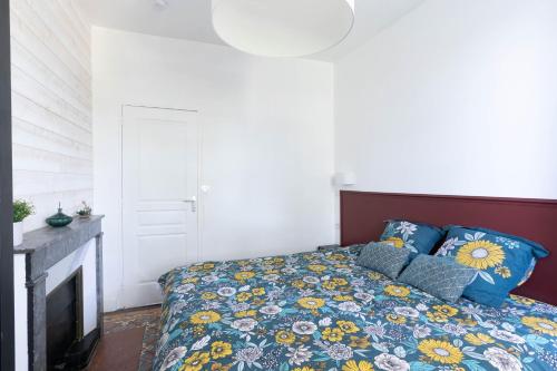 a bedroom with a bed and a fireplace at T3-Isabelle et Christian in Mâcon