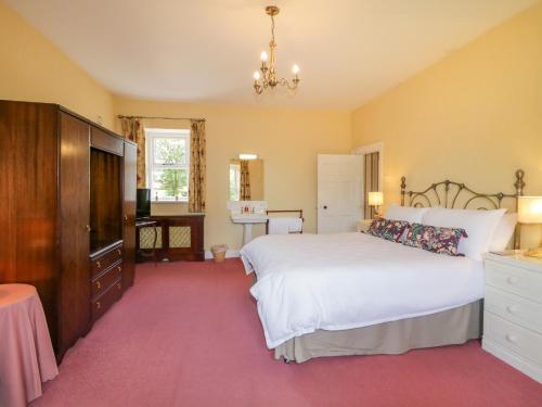 ein Schlafzimmer mit einem Bett, einer Kommode und einem Fernseher in der Unterkunft The Haw Country Home in Bushmills