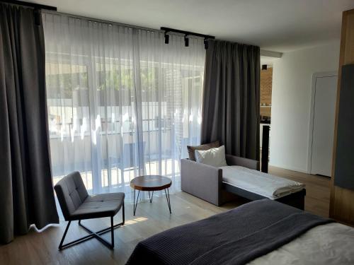 a bedroom with a bed and a couch and a chair at VISLOW Resort in Wisła