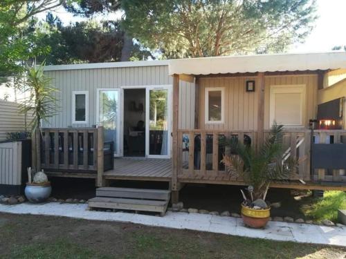 une petite maison avec une grande terrasse dans l'établissement Le mobilhome de Maelya, à Saint-Cyprien