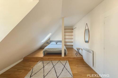 une chambre avec un lit dans un grenier dans l'établissement Flexliving - room - Bausset, à Paris