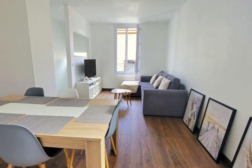 un salon avec une table et un canapé dans l'établissement Le Fort - Maison individuelle proche Stade de France, à Aubervilliers