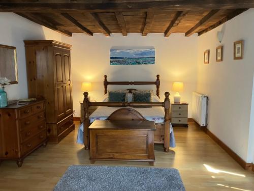 - une chambre avec un lit en bois et une commode dans l'établissement Puyleger, à Saint-Privat-des-Prés