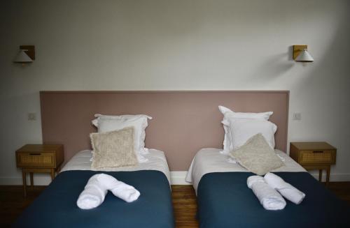 two beds with towels on them in a bedroom at La Maison du Gasseau in Saint-Léonard-des-Bois