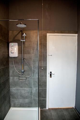 a shower with a glass door in a bathroom at Spacious 2-Bedroom Flat with 4 Beds, Ideal for Contractors, Long Stay Deals in Wallasey