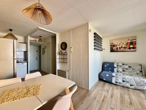 Il dispose d'une cuisine et d'un salon avec une table et un canapé. dans l'établissement Appartement Cap d'Agde, au Cap d'Agde