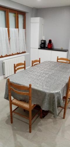 une table à manger avec quatre chaises et une table dans l'établissement La huberdiere, à Surville