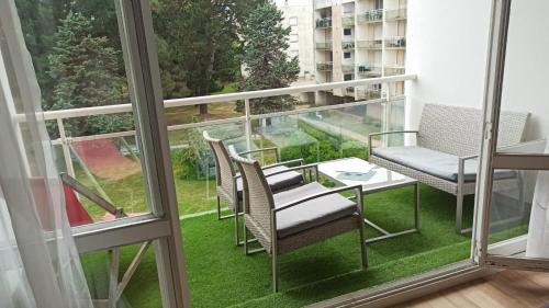 d'un balcon avec des chaises, une table et une fenêtre. dans l'établissement Studio calme, à Carnac