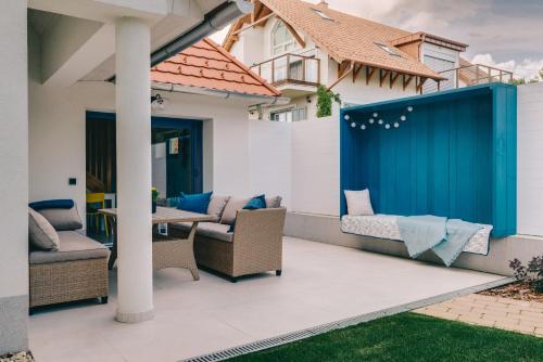 a patio with chairs and a blue gate at CsakAkali in Balatonakali
