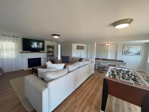 a living room with a large couch and a foos ball at Waterfront, Hottub, Petsok, Firepit, Pooltable in Dennis