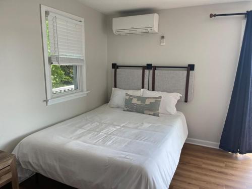 a bedroom with a large white bed with a window at Waterfront, Hottub, Petsok, Firepit, Pooltable in Dennis