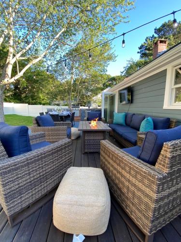 a patio with wicker furniture and a fire pit at Close2beach, Speakeasybar,hottub, Petsok, Firepit in Dennis