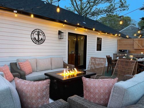 a patio with chairs and a table with a fire pit at 5mins2beach, Hottub, Gameroom, Petsok in Dennis