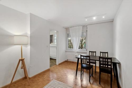 a dining room with a black table and chairs at Beautiful Boutique Apartment DRAHTZUG8 in Zürich