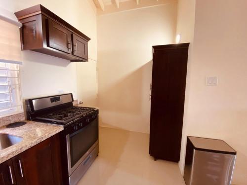 a kitchen with a stove and a sink at Jhadano 3br Pool & Gym Shuttle Gated in Florence Hall