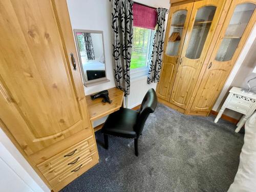 a bedroom with wooden cabinets and a black chair at Celtic Lodges in Thurso