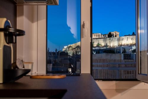 a room with a large window with a view of a city at Unique 2BR Penthouse with Stunning Acropolis View in Athens
