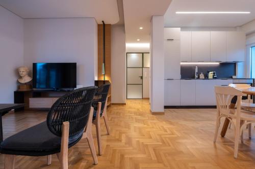 a living room with a table and chairs and a kitchen at Unique 2BR Penthouse with Stunning Acropolis View in Athens