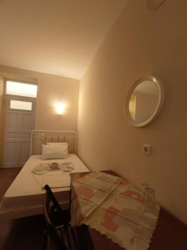 a small room with a bed and a mirror at Anesis Hotel in Loutra Edipsou