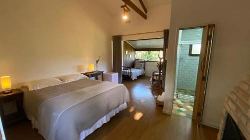 a bedroom with a large bed and a living room at Pousada Caminhos de Gaia in São Francisco Xavier