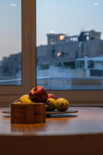 a pile of fruit sitting on a table next to a window at Unique 2BR Penthouse with Stunning Acropolis View in Athens