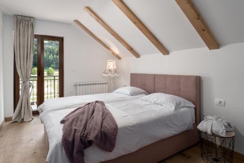 a bedroom with a large bed and a window at Mountain Houses Volta in Lič