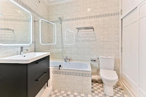 une salle de bain avec un lavabo, des toilettes et une baignoire dans l'établissement Appartement proche Gare Montparnasse - IV, à Paris