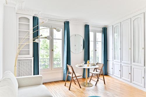 un salon avec une table et des chaises dans l'établissement Appartement proche Gare Montparnasse - IV, à Paris