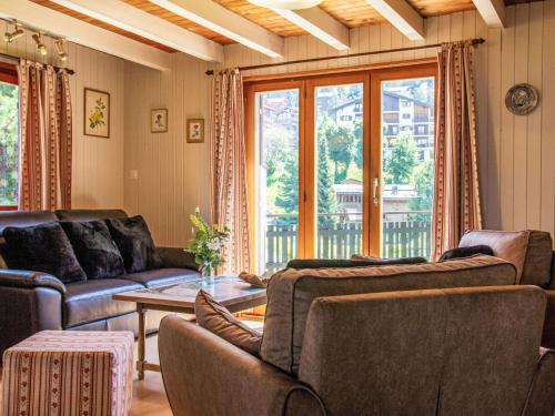a living room with couches and a table at Chalet Peer Gynt by Interhome in Nendaz