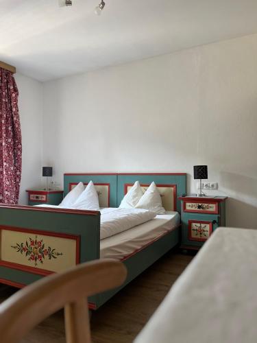 a bedroom with a bed and two night tables at Gasthof Sterzingerhof in Vipiteno
