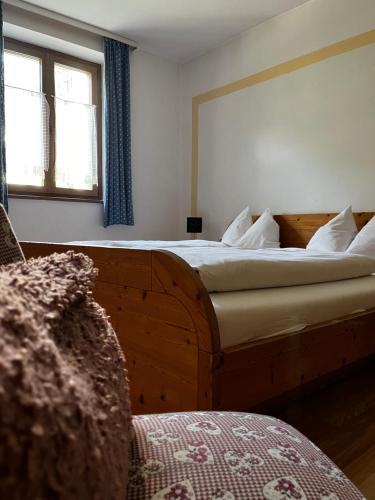 a bedroom with a large wooden bed with a window at Gasthof Sterzingerhof in Vipiteno