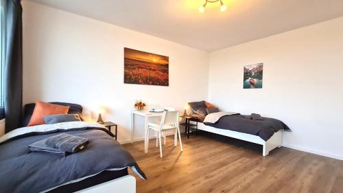 a bedroom with two beds and a desk and a table at Perfekte Monteurswohnung in Schwerte