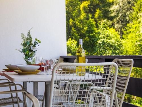 a white table and chairs with a bottle of wine at Apartment Chaedoz 43 by Interhome in Nendaz