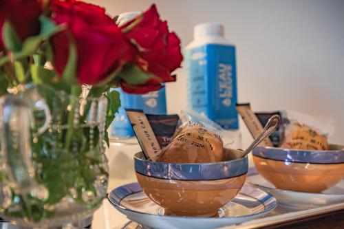 a table with three bowls of food and a vase with roses at Ostal Cassinia in Cassagne