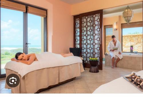 Una donna sdraiata su un letto in una stanza d'albergo di Villa mazagan golf and beach resort a Azemmour