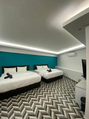 a room with two beds and a television in it at HOTEL HOMESTAY MACHANG D Sega in Machang