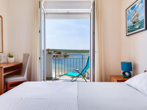 a bedroom with a bed and a desk and a balcony at Apartment Daria 2 by Interhome in Anić