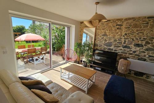 un salon avec un canapé et un mur en pierre dans l'établissement La Fontaine gîte de charme à 12min du Puy duFou, à Sevremont