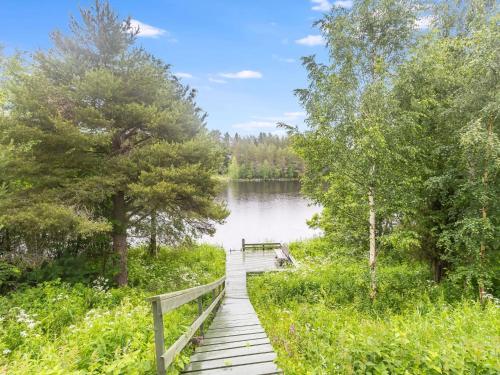 um calçadão de madeira que leva a um lago com árvores em Holiday Home Tarvastupa by Interhome em Kemijärvi