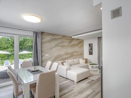 a living room with a white couch and a table at Holiday Home Forest Fairy by Interhome in Raša