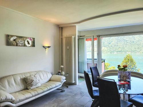 a living room with a couch and a table at Apartment Frontlake Panorama Apt- 408 by Interhome in Bissone