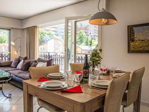 Un comedor con una mesa y un sofá. en Apartment Bouleaux A1 by Interhome, en Nendaz