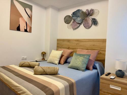 una camera da letto con due letti e un dipinto sul muro di Gran ático con terraza en el centro de Alicante ad Alicante