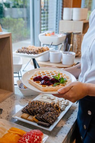 a person holding a plate of food on a table at Hotel Oliwski in Gdańsk