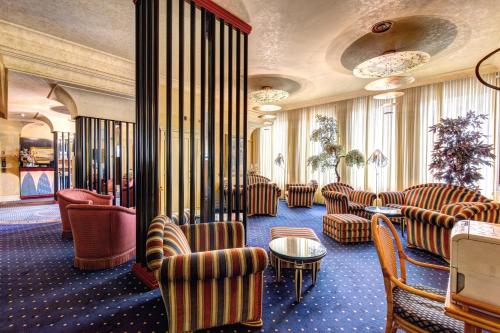 a waiting room with couches and chairs and a table at Hotel Auriga in Milan