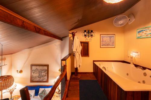 a bathroom with a large tub in a room at Pousada Do Lado de Lá in Pirenópolis