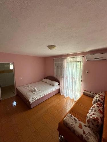 a bedroom with a large bed and a window at Stellax Apartment in Donji Štoj