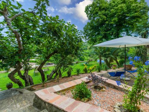 a garden with an umbrella and a pathway at Holiday Home La Torre-4 by Interhome in Stigliano