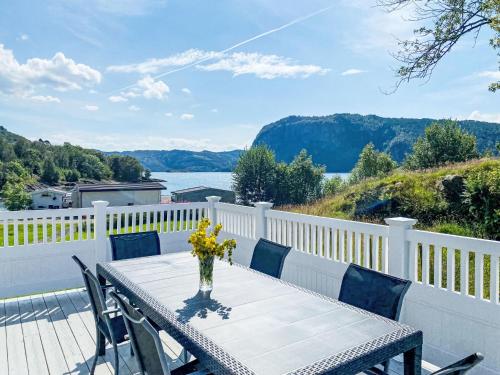 a table with a vase of flowers on a balcony at Holiday Home Sjøtun by Interhome in Hyllestad