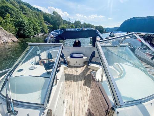 a boat with glass doors on a river at Holiday Home Sjøtun by Interhome in Hyllestad